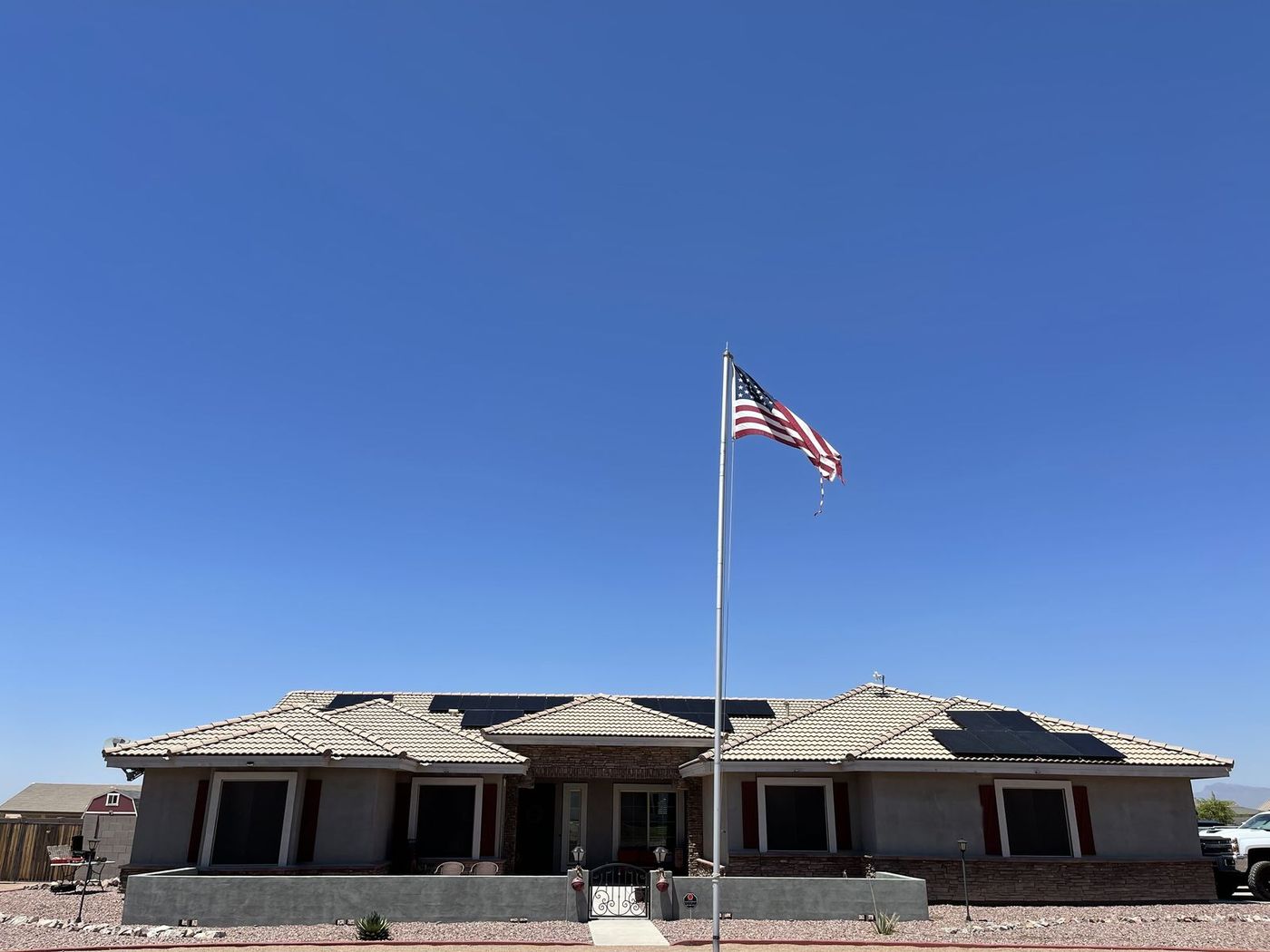 Single-story home with rooftop solar panels under a clear blue sky
